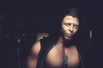 Handsome guy posing in hood. Bodybuilder