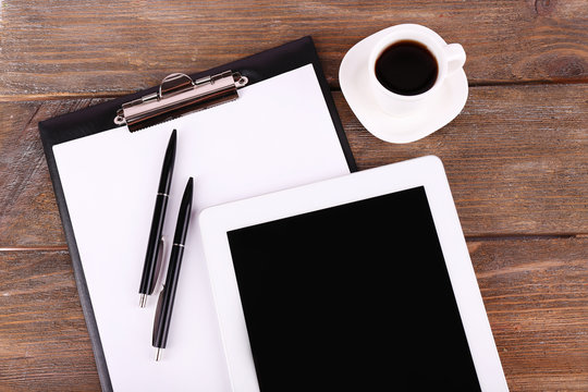 Tablet, cup of coffee, pens and folder with paper