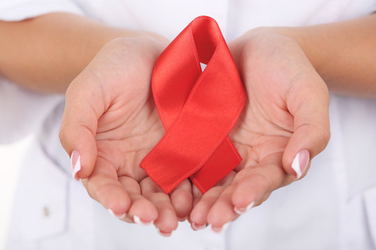 Woman with aids awareness red ribbon in hands isolated on white