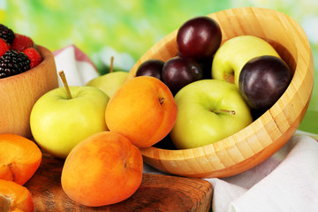 Naklejka na ściany i meble Ripe fruits and berries on table on bright background