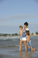 Happy mother and daughters having fun on the beach.