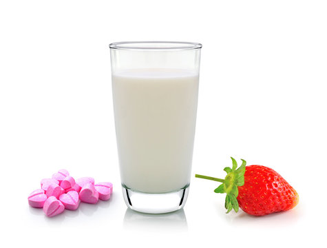 glass of milk vitamin c and strawberry on white background