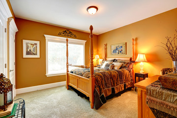 Cozy bedroom with carved wood bed and high poles