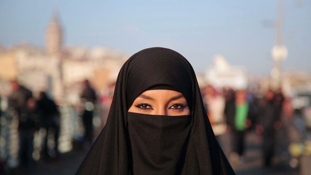 Woman dressed with black headscarf, chador on istanbul street, turkey