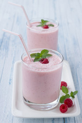 Milkshake with fresh raspberries in a glass
