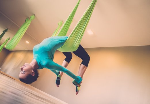 Young Woman Performing Aerial Yoga Exercise