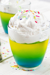 Multicolored jelly with whipped cream and candy topping