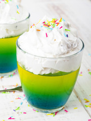 Multicolored jelly with whipped cream and candy topping