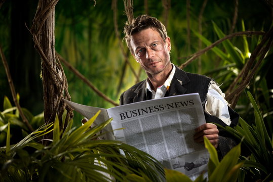 Businessman reading financial news in the jungle