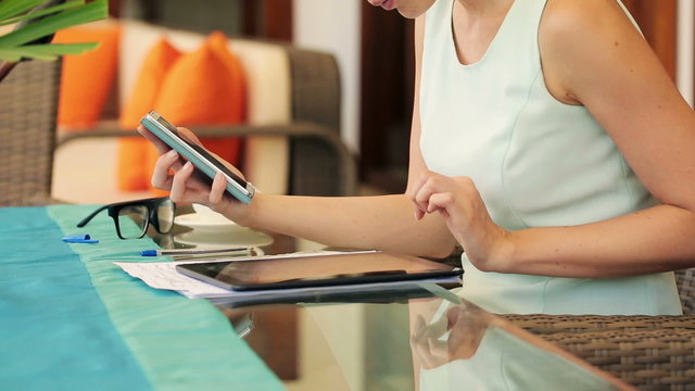 Businesswoman comparing data on smartphone and tablet by the tab