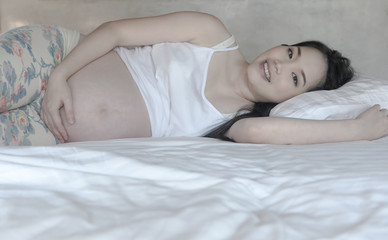 Obraz na płótnie Canvas A pretty young pregnant asian woman