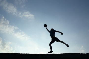 Fototapeta na wymiar Silhouette of man playin basketball
