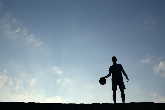 Silhouette of man playin basketball