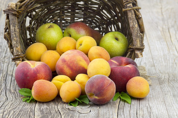 fresh fruits in a basket on wooden background