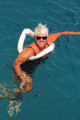 A lady relaxing in the clear sea waters while on vacation