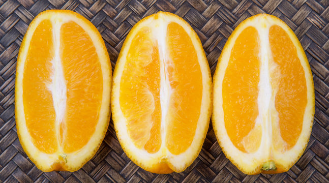 Slice of orange fruit over wicker background 