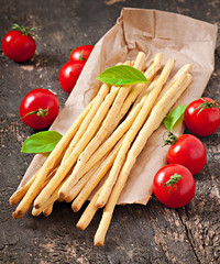Grissini bread sticks on old wooden background