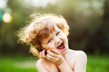 Happy child talking on mobile phone.