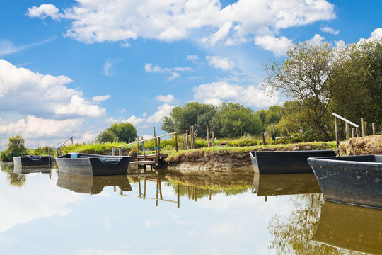 wooden boats near gangways on lake, France