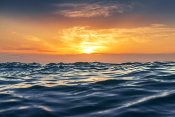 Plakaty  Wschód słońca i lśniące fale w oceanie