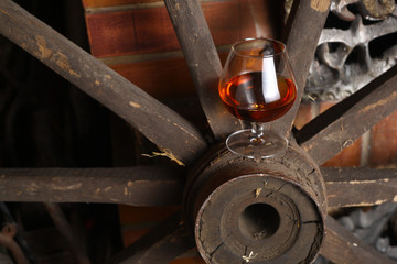 Glass of brandy on wooden wheel