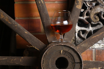 Glass of brandy on wooden wheel