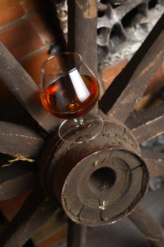 Glass of brandy on wooden wheel