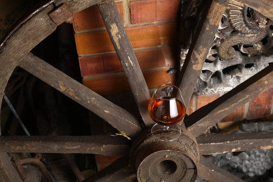 Glass of brandy on wooden wheel