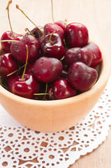 Fresh cherries in bowl on table