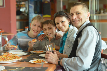 Cute family eating pizza