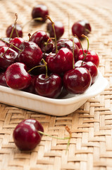 Fresh cherries in bowl on table