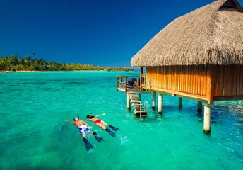 Printed kitchen splashbacks Bora Bora, French Polynesia Young couple snorkling from hut over tropical lagoon