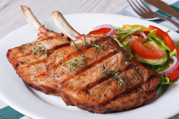 Grilled pork with fresh vegetables on a white plate. close up
