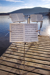 Drei Notenständer auf einem Steg am See