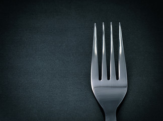 Steel fork on black background
