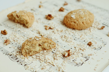 Homemade oatmeal cookies with walnut on vintage music sheet