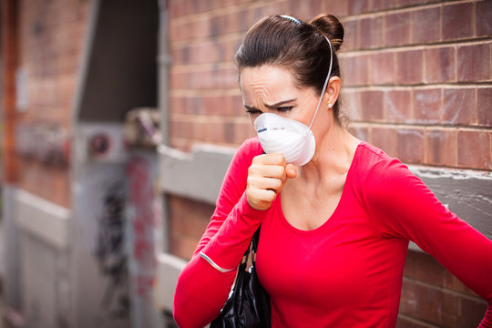 Woman wearing facemask coughing