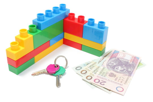 Wall of plastic building blocks with home keys and money