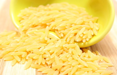 Yellow pasta pouring out of glass bowl