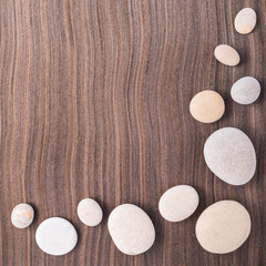 Fototapeta na wymiar light pebbles on wooden ebony tree background