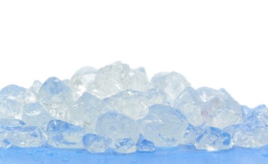 Chunks of crushed ice on blue surface and white background