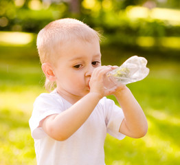 little boy drinking fresh water in the park