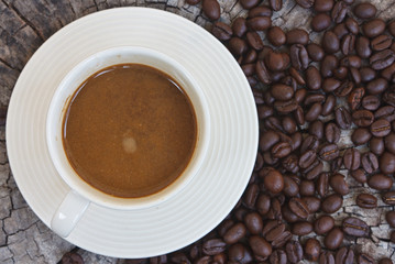 White cup in coffee beans, closeup