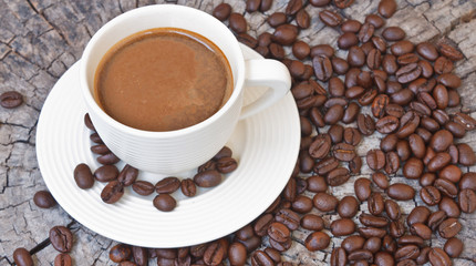 White cup in coffee beans, closeup