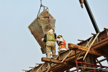 Two construction workers casting beam