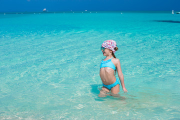 Adorable little girl in the sea on tropical beach vacation