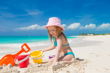 Adorable little girl playing with toys on beach vacation