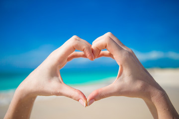 Heart made by hands background the turquoise ocean