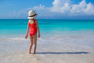 Little girl in hat at beach during caribbean vacation