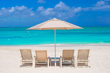 White umbrellas and sunbeds at tropical beach